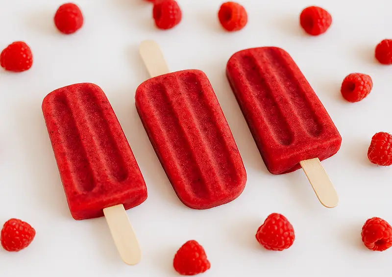 Raspberry Raspberry Popsicles surrounded by raspberries